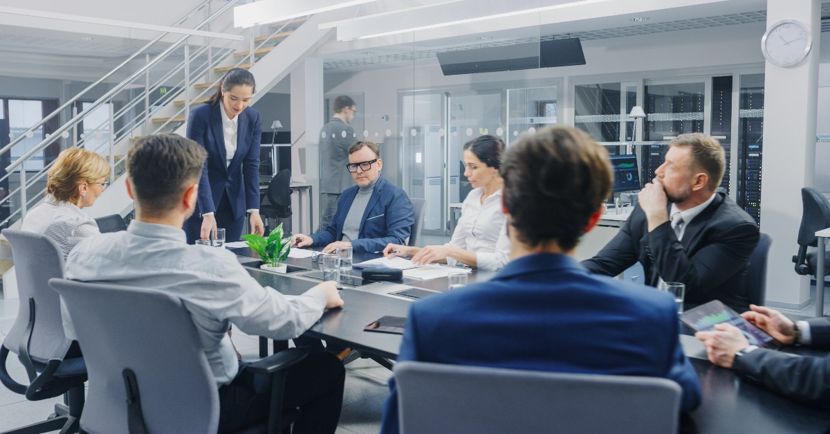 Executivos analisando documentos financeiros em reunião corporativa